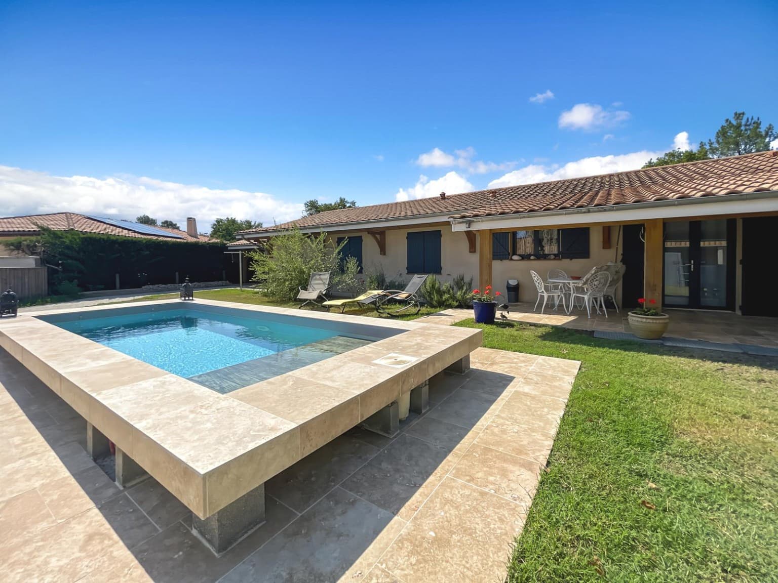 Piscine, jardin et terrasse couverte devant la maison au Teich.