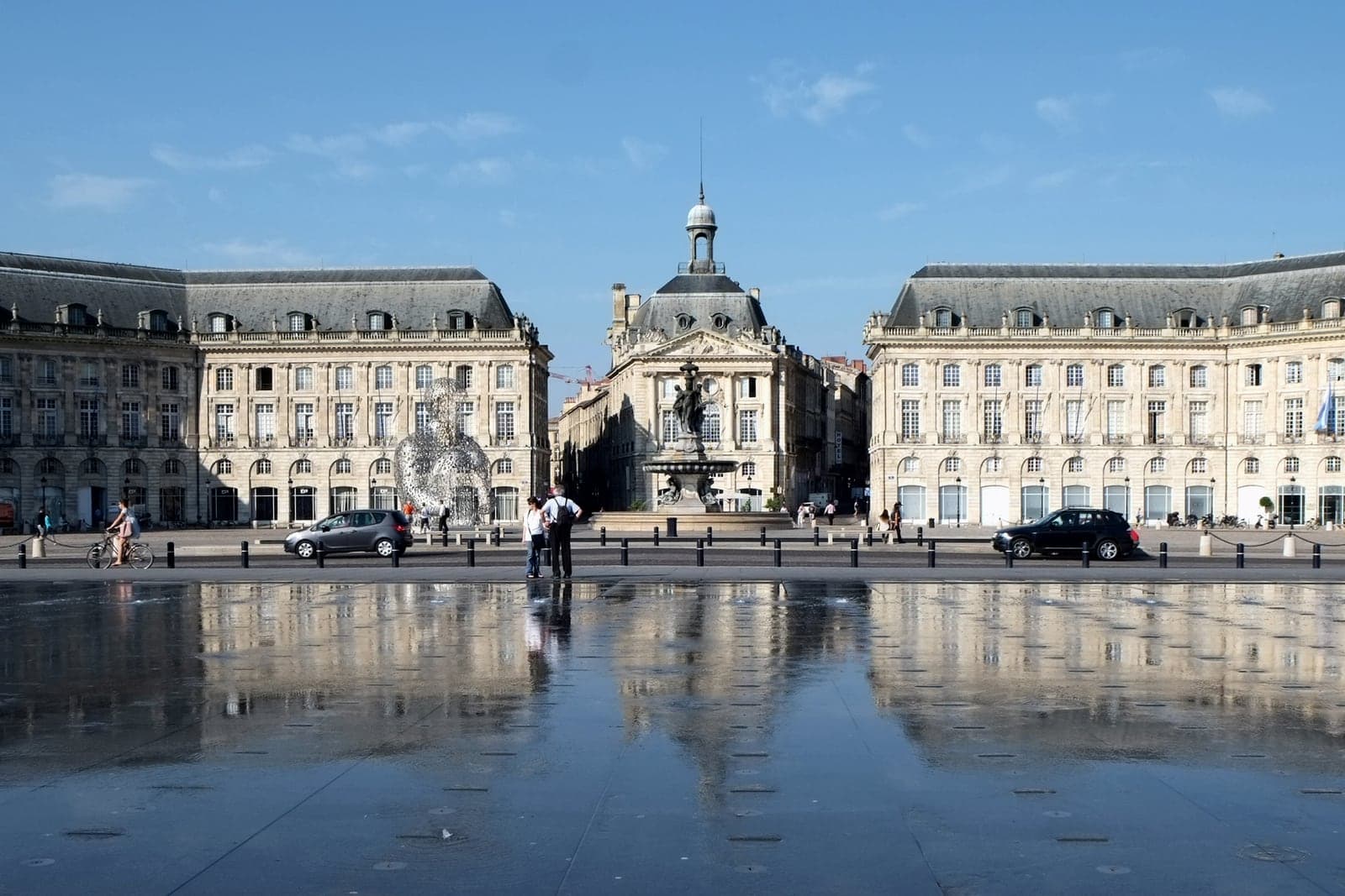 Place de la Bourse et ses façades en pierre blonde, reflétées dans le miroir d'eau à Bordeaux.